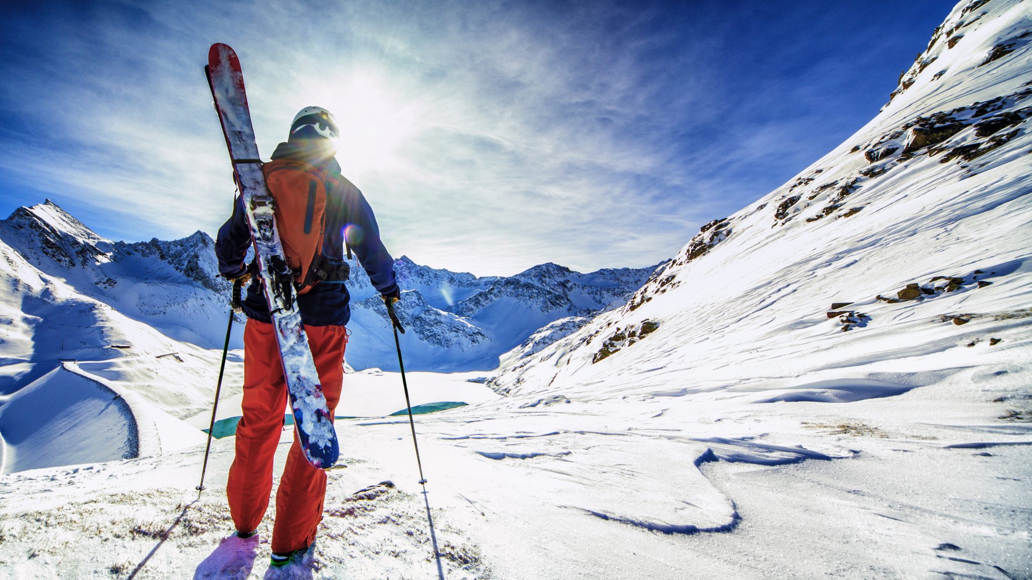 What is the danger of wearing loose clothing when riding a snowmobile?